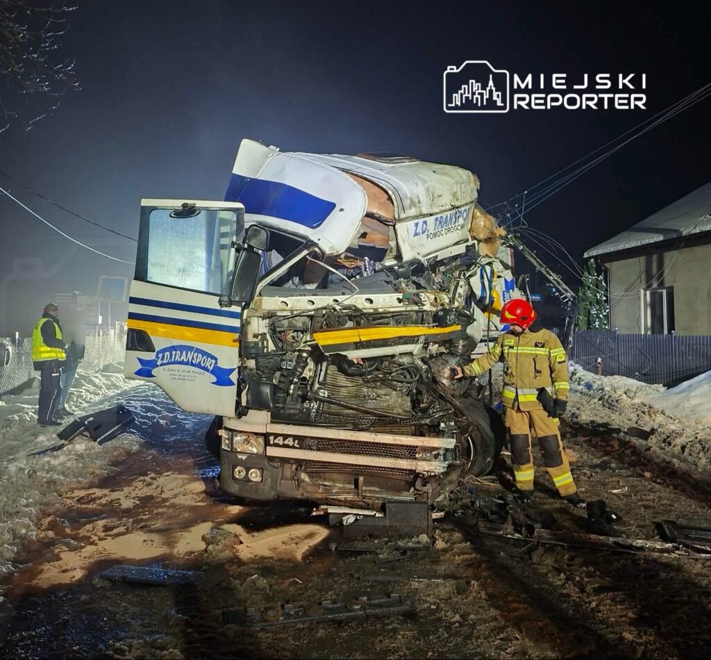 Cysterna przewożąca ładunek leży na boku, a strażacy w mundurach pracują przy uszkodzonej kabinie w zimowym otoczeniu.