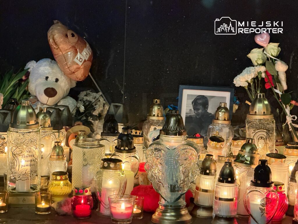 Na ołtarzu pamięci znajduje się wiele zniczy, pluszowy miś, balon oraz zdjęcie uśmiechniętego chłopca.