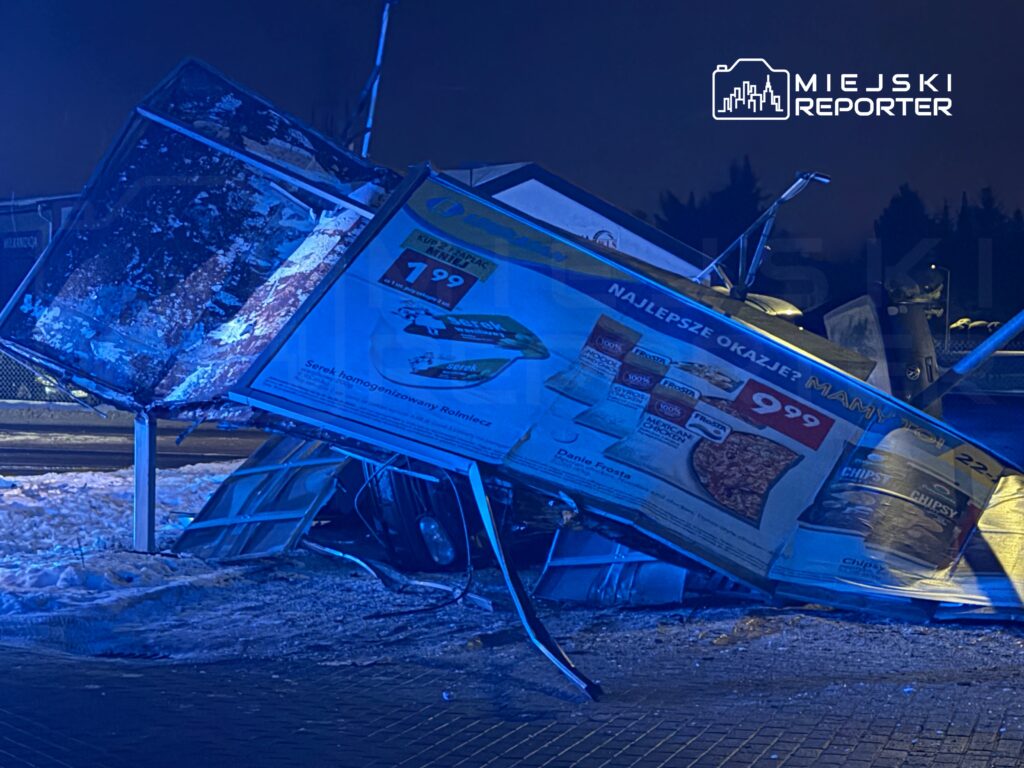 Zniszczona reklama na przystanku autobusowym, oparta na boku, z widocznymi produktami spożywczymi i cenami.