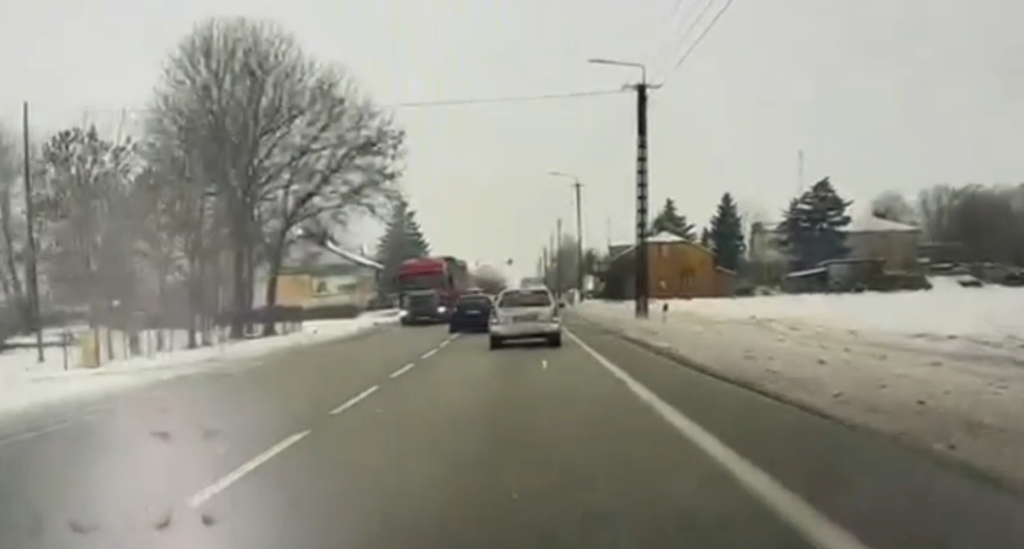 Droga w zimowej scenerii, samochody poruszające się w kierunku przeciwnym, śnieg pokrywający pobocze.