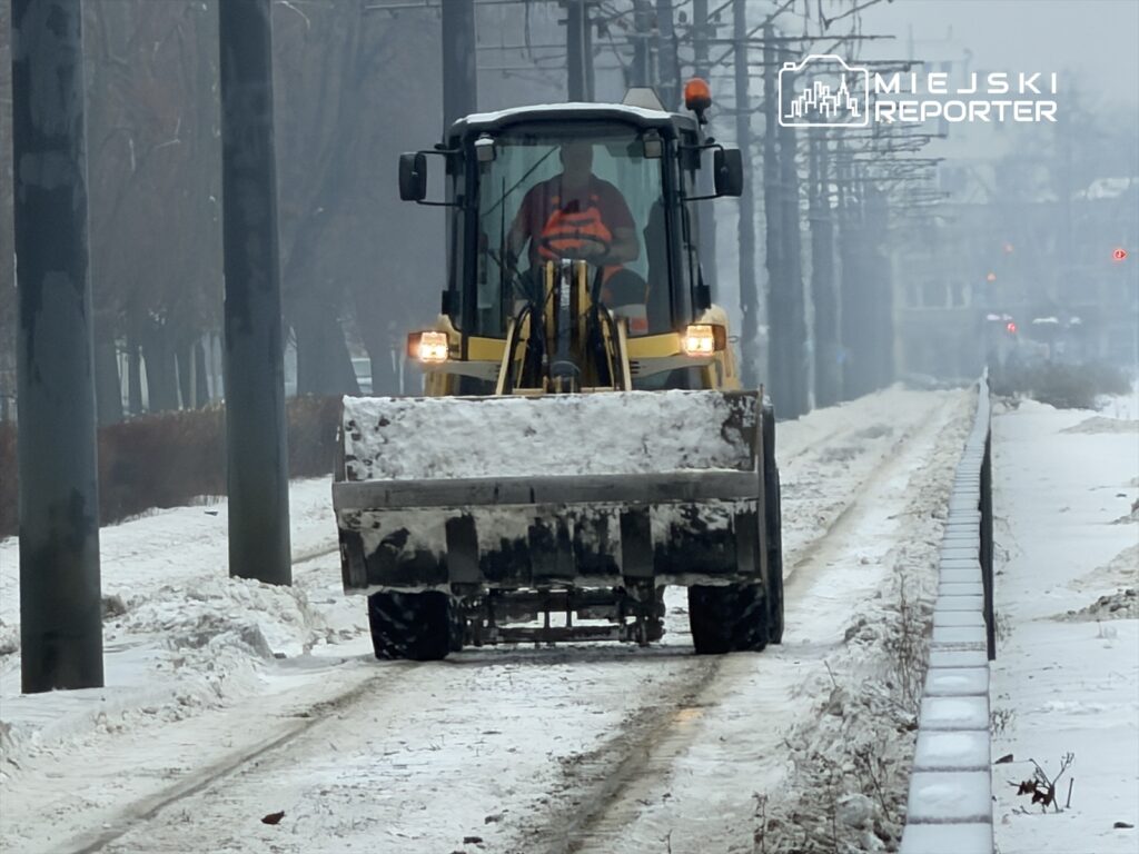 Maszyna do odśnieżania usuwa śnieg z torowiska w zimowym, miejskim otoczeniu.