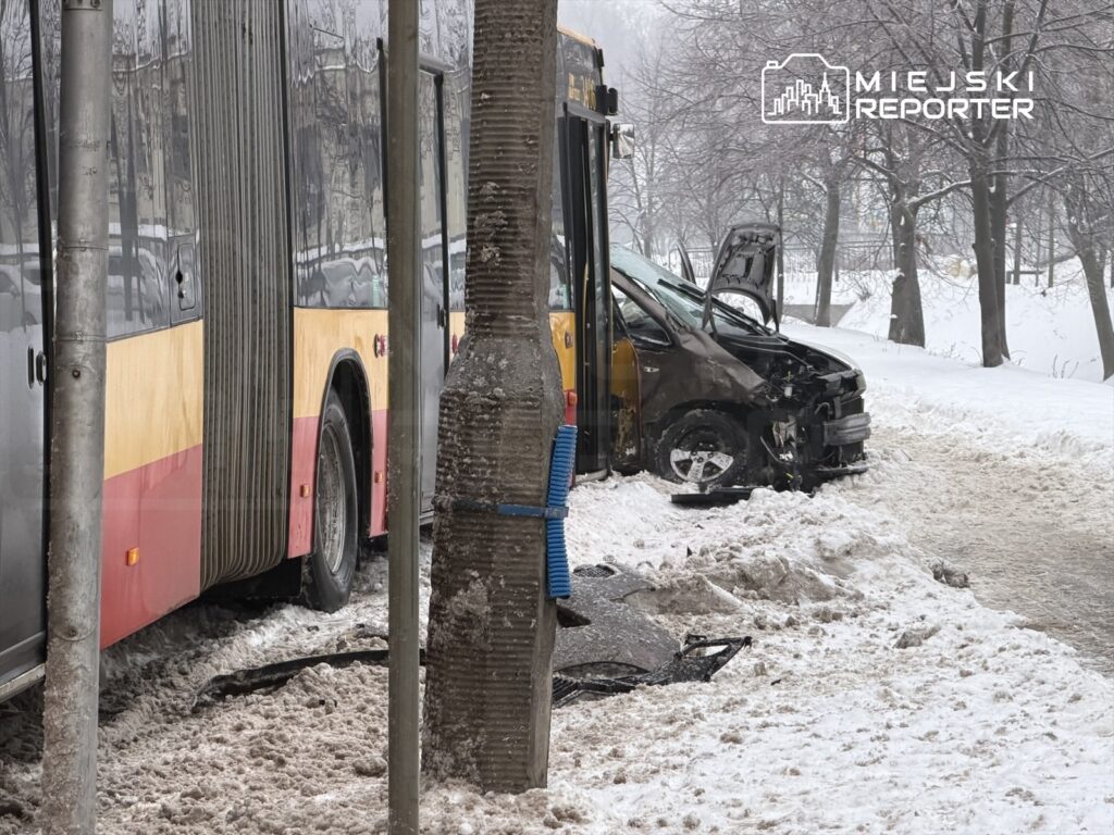 Zderzenie autobusu z osobowym samochodem na zaśnieżonej ulicy, obok widoczny uszkodzony pojazd.
