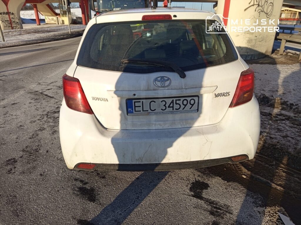 Biały samochód marki Toyota Yaris zaparkowany na zimowej nawierzchni drogi, z widoczną rejestracją ELC 34599.