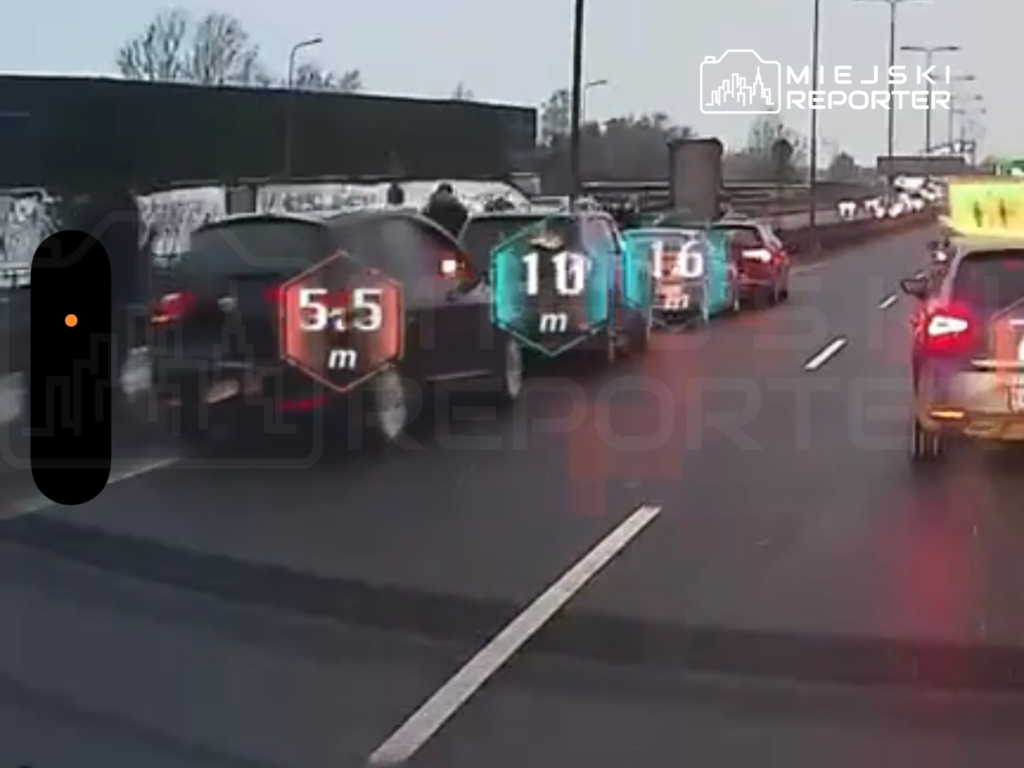 Ruch uliczny na drodze ekspresowej z widocznymi odległościami między pojazdami, oznaczonymi cyfrowo.