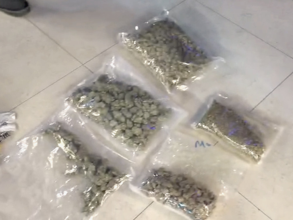 Sześć przezroczystych torebek z suszem roślinnym leży na podłodze w jasnym otoczeniu.