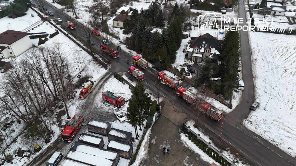 Wielka akcja ratunkowa z udziałem wielu wozów strażackich w zaśnieżonej okolicy mieszkalnej.