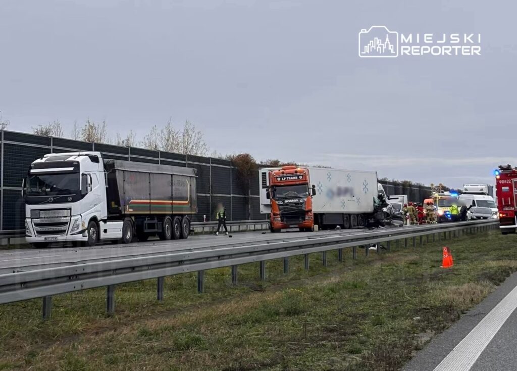 Zespół ratunkowy pracuje przy wypadku drogowym na autostradzie, obok uszkodzonej ciężarówki.
