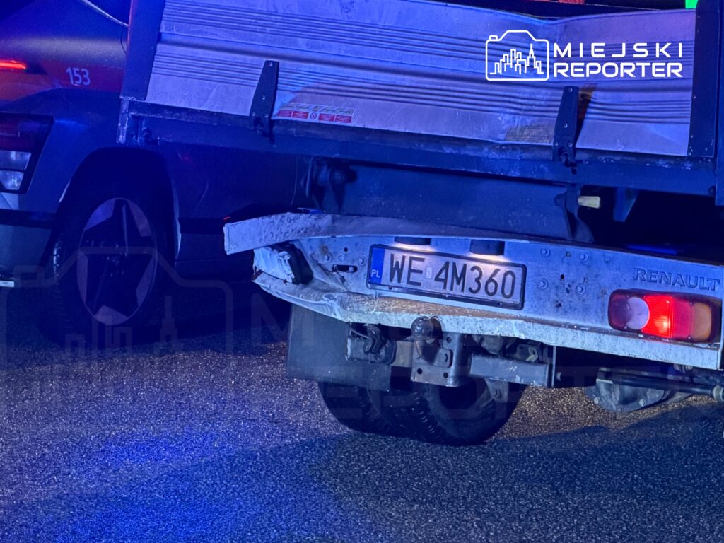 Zepsuty samochód dostawczy marki Renault z widoczną tablicą rejestracyjną WE 4M360 na ciemnej nawierzchni drogi.