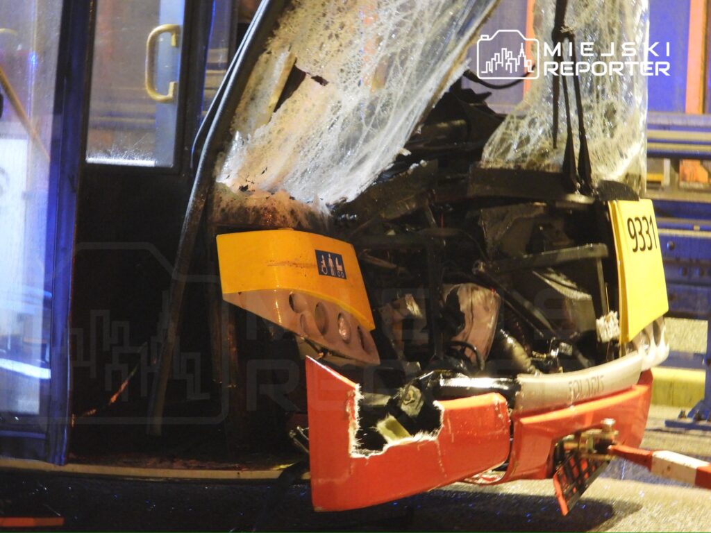 Zniszczony przód autobusu miejskiego z numerem 9331, uszkodzenia widoczne na masce i szybce, w nocnym otoczeniu.