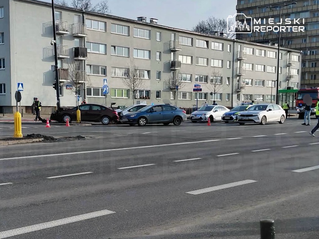 Policjant kierujący ruchem obok zderzenia kilku samochodów na ruchliwej ulicy w miejskim otoczeniu.