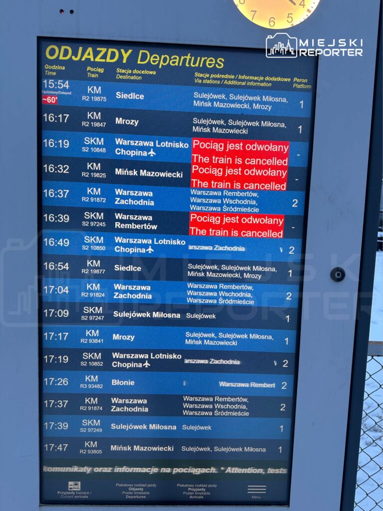 Tablica odjazdów na stacji kolejowej z informacjami o pociągach, w tym ogłoszenia o odwołanych kursach.