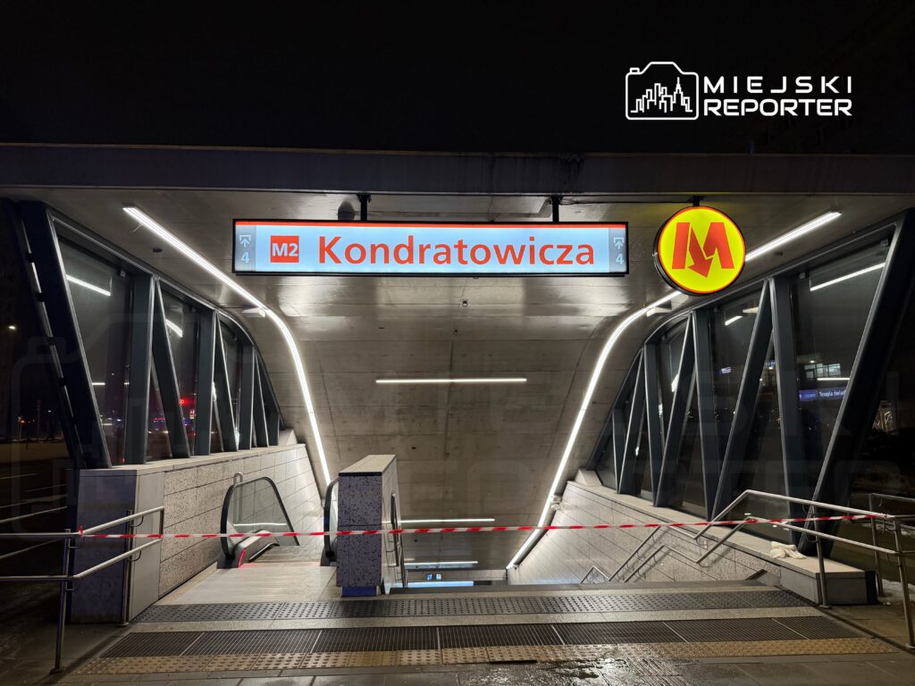 Nowoczesne wejście na stację metra z jasnym oznaczeniem "Kondratowicza" i podświetloną literą "M".