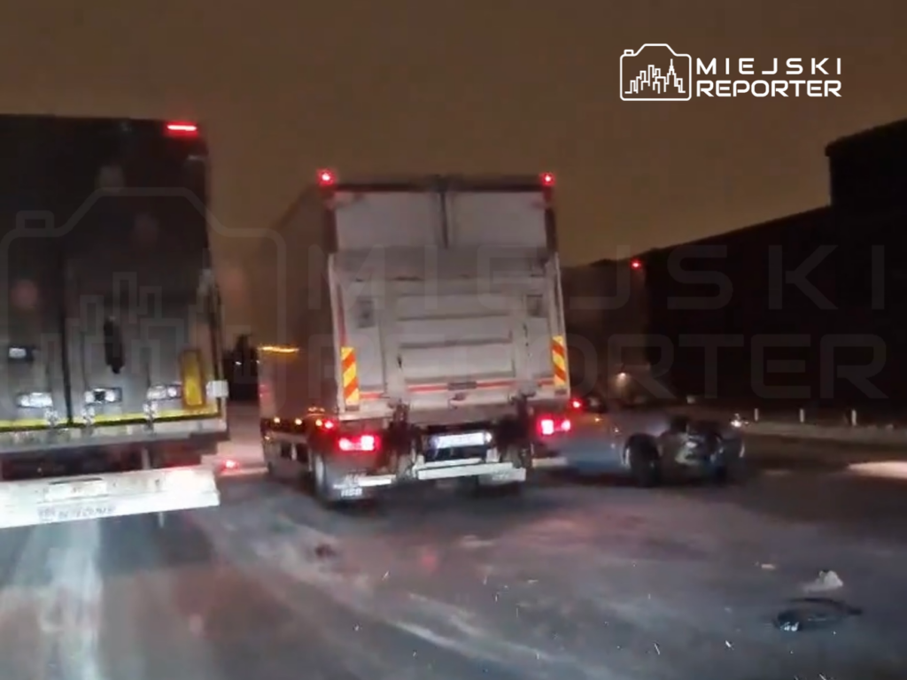 Na drodze w nocy doszło do wypadku, w którym uczestniczą dwa ciężarowce i osobowy samochód z uszkodzoną przednią częścią.