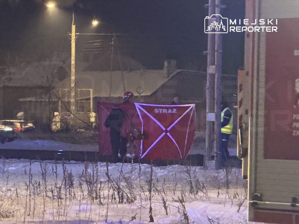 Ratownicy w odblaskowych kamizelkach ustawiają czerwony namiot oznaczony napisem "STRAŻ" w zaśnieżonym terenie.