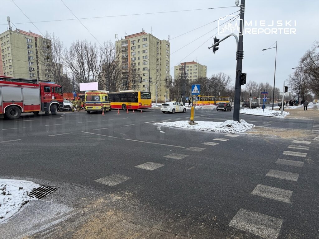 Na skrzyżowaniu widoczna jest straż pożarna oraz karetka pogotowia, otoczone przez pojazdy i zamarznięty krajobraz.