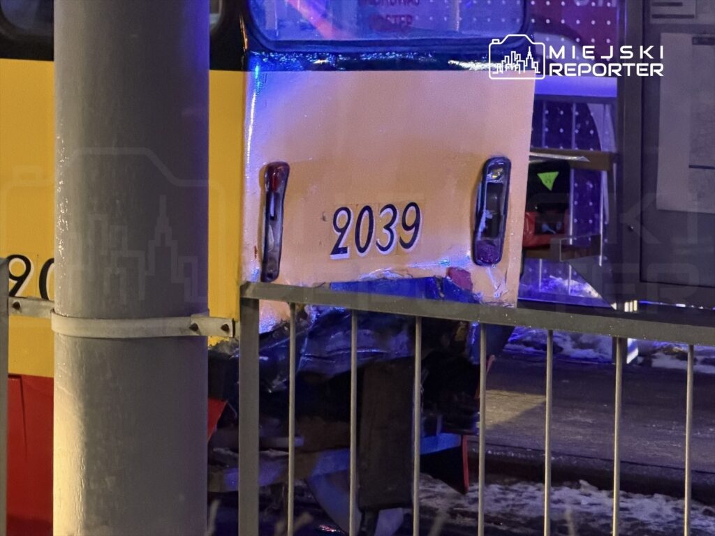 Uszkodzony tramwaj o numerze 2039 stoi obok metalowego słupa, z widocznymi śladami uszkodzeń na tylnej części.