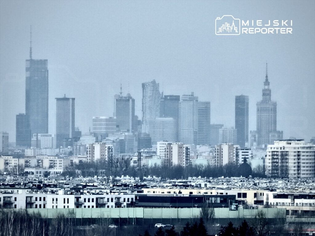 Panorama nowoczesnych wieżowców w mieście, w tle widoczny charakterystyczny budynek z wieżą.