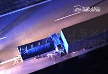 Zniszczony ciężarówka leżąca na poboczu drogi, otoczona niebieskim światłem sygnalizacji.