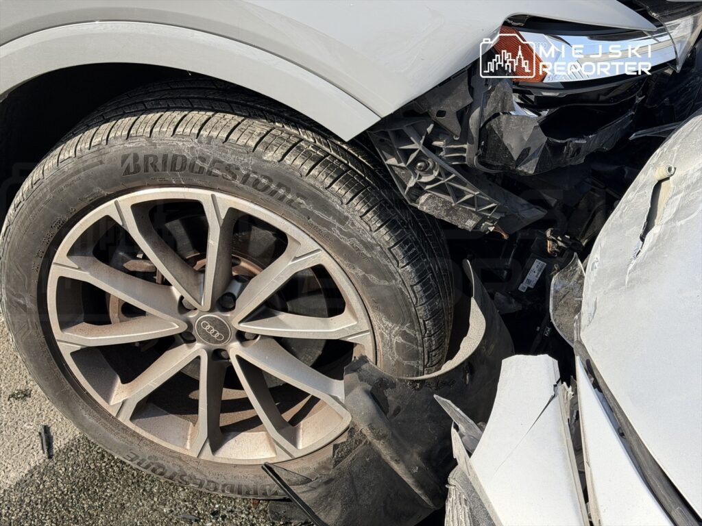 Uszkodzone koło samochodu osobowego z widoczną oponą marki Bridgestone oraz zniszczonym nadwoziem w okolicy zderzaka.