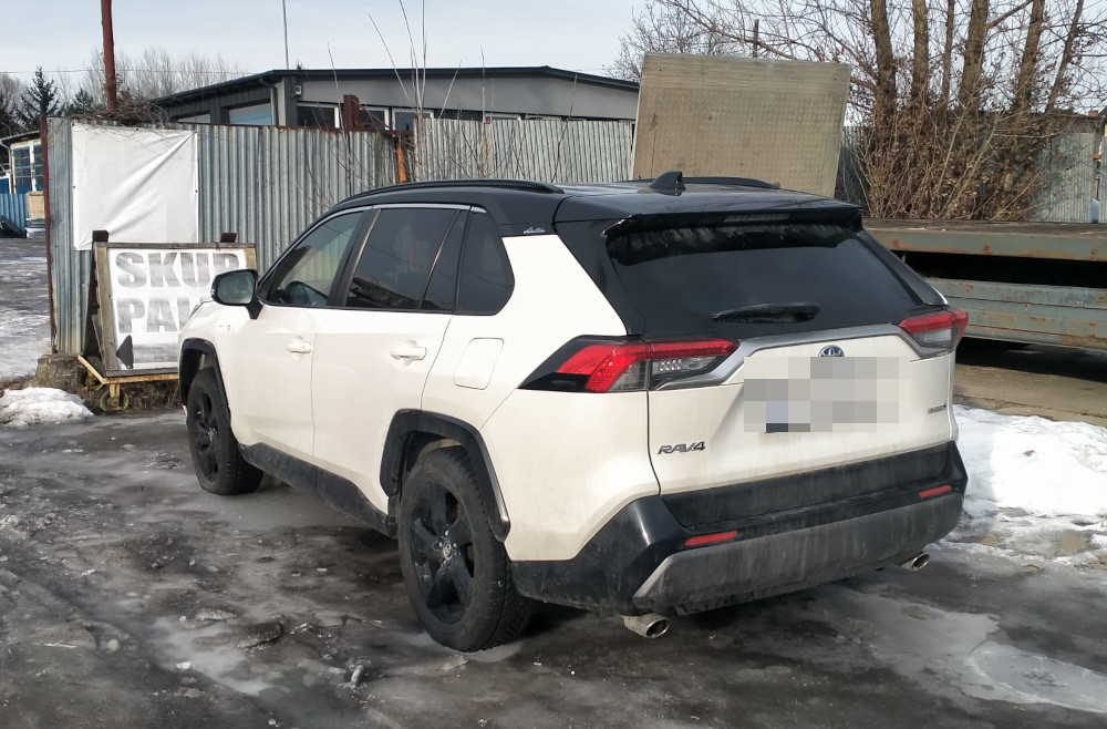 Biały SUV z czarnym dachem zaparkowany na ośnieżonym placu, w tle widoczny znak "SKUP PAW".