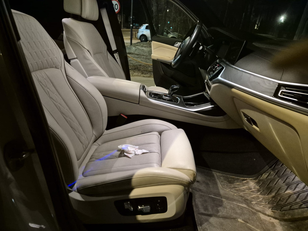 Nowoczesne wnętrze samochodu z jasnymi skórzanymi fotelami i eleganckim wykończeniem deski rozdzielczej.