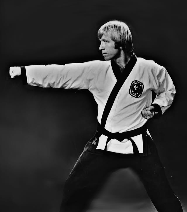 Mężczyzna w kimono wykonujący technikę karate na czarnym tle.