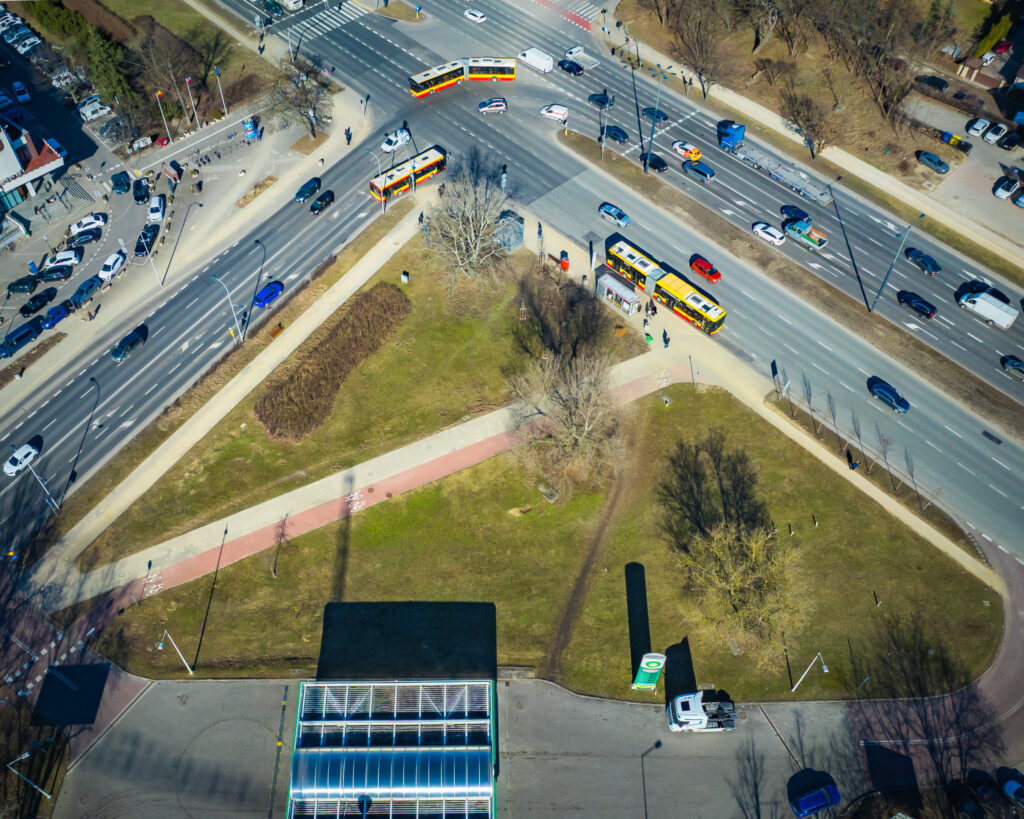 Widok z góry na skrzyżowanie z ruchliwymi ulicami, tramwajem i parkiem w centrum miasta.