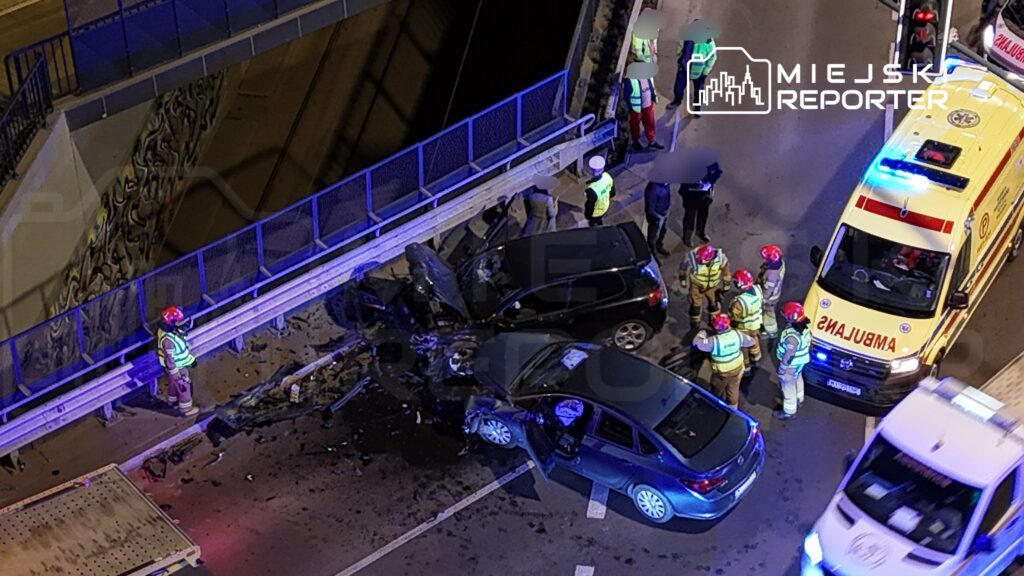 Wielu ratowników medycznych i strażaków pracuje nad wypadkiem drogowym, w którym zderzyły się dwa samochody osobowe.