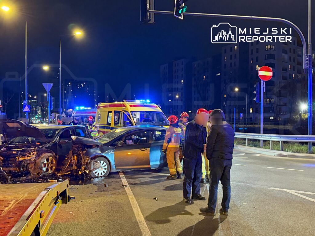 W nocy na skrzyżowaniu dwóch ulic doszło do wypadku, w którym zderzyły się dwa samochody. Ratownicy medyczni oraz strażacy udzielają pomocy poszkodowanym.