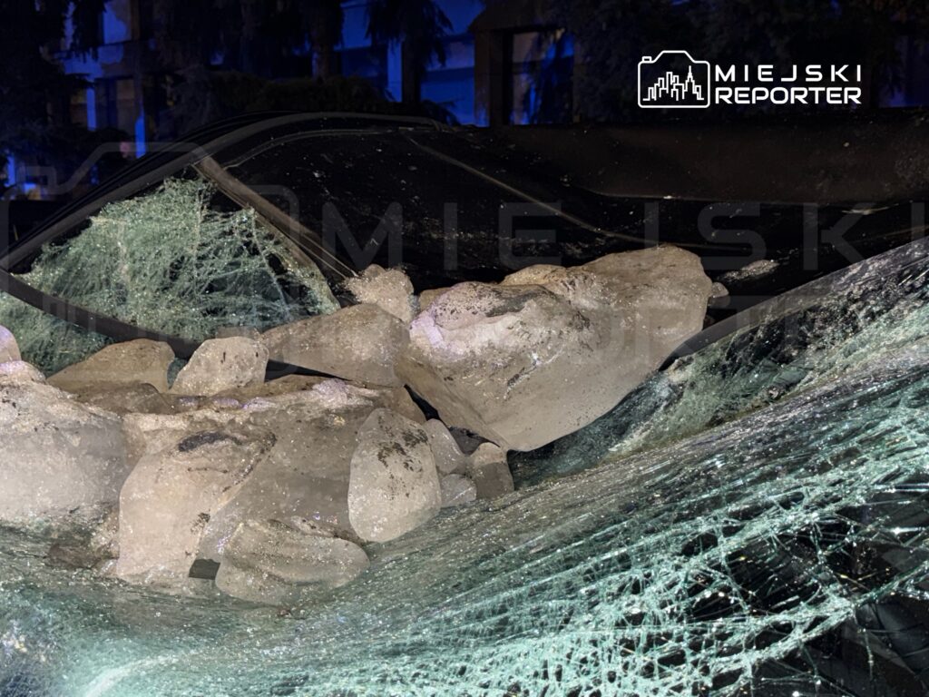 Rozbite szyby samochodu pokryte dużymi bryłami lodu w ciemnym otoczeniu.