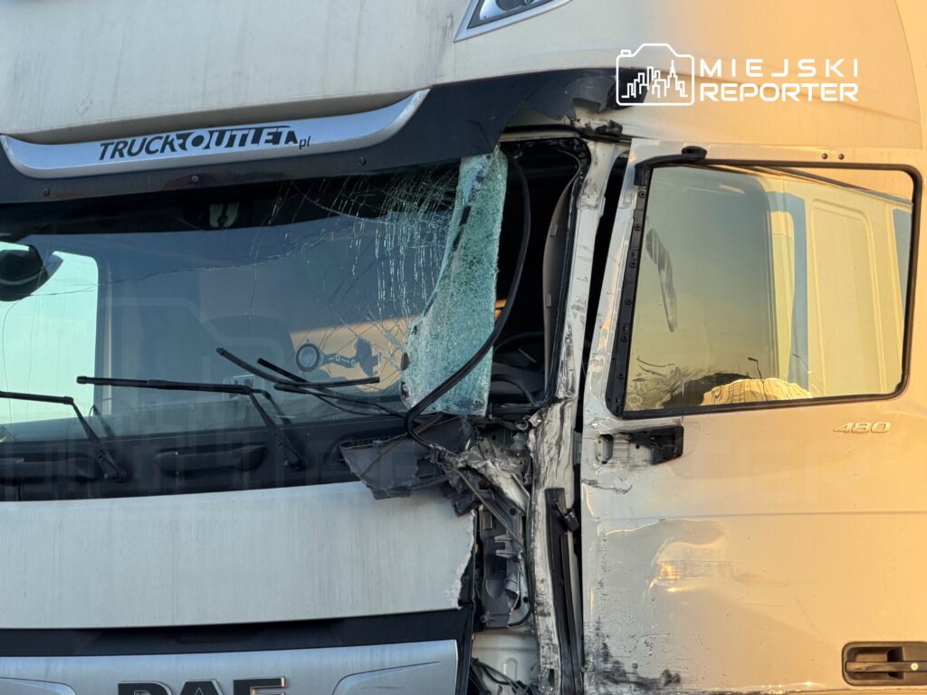 Uszkodzony ciężarowy pojazd DAF z rozbityą szybą i wgniecioną karoserią, zaparkowany w słonecznym otoczeniu.