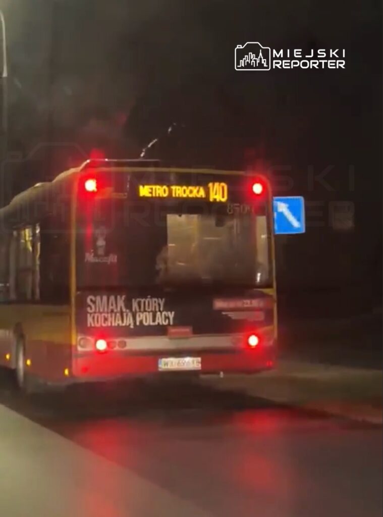 Autobus linii 140 z napisem "METRO TROCKA" zatrzymany na nocnej ulicy, z widocznym reklamowym nadrukiem na boku.