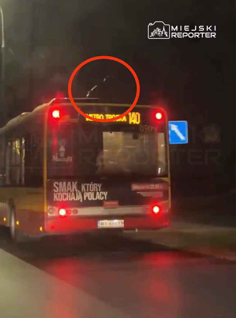 Autobus miejski z numerem 140 zatrzymany na ulicy, z widocznymi reflektorami i reklamą na tylnej części.