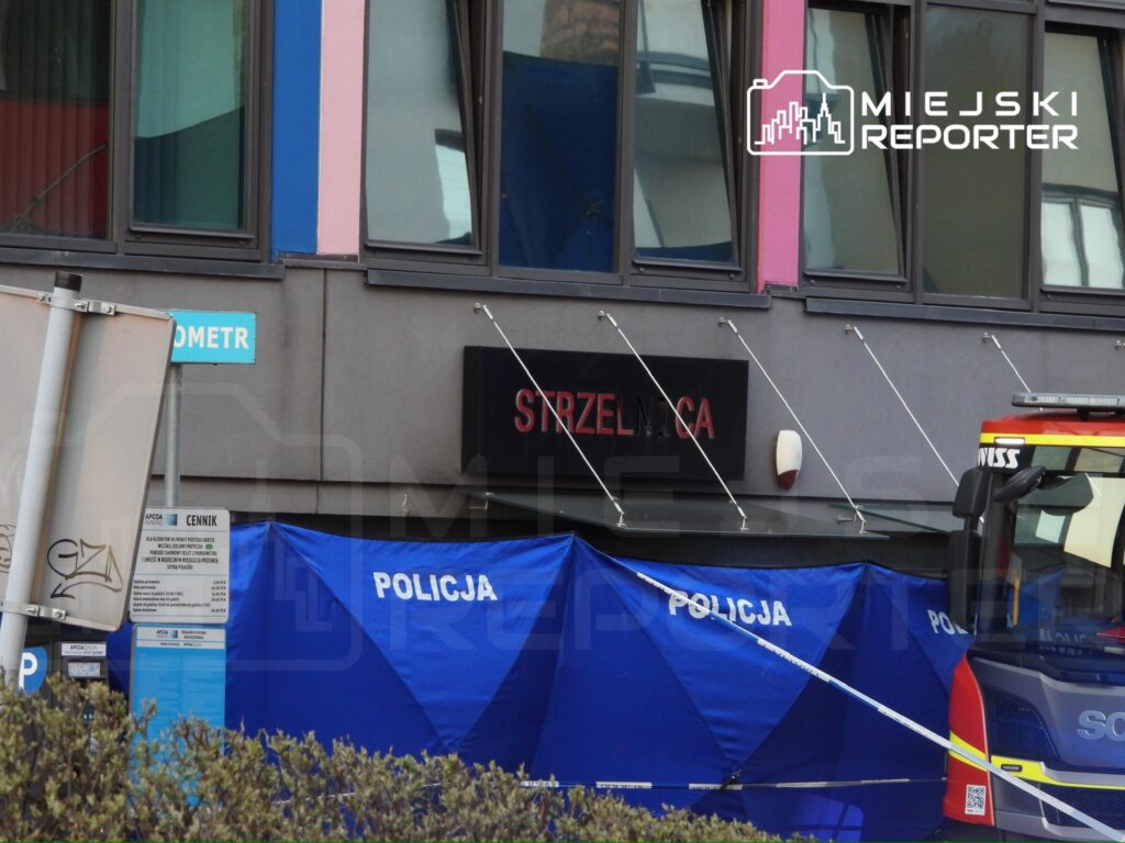 Policja ustawia niebieskie namioty na chodniku przed budynkiem z napisem "STRZELNICA".