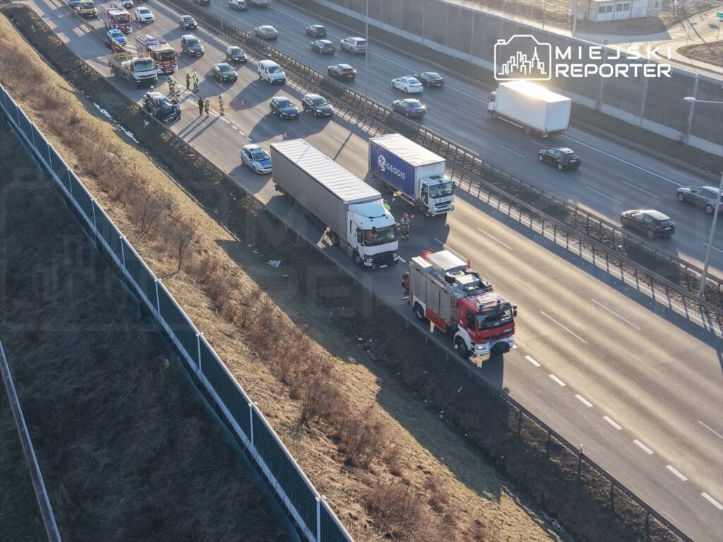 Na drodze krajowej zatrzymane pojazdy, w tym ciężarówki, oraz samochód straży pożarnej interweniujący w miejscu zdarzenia.