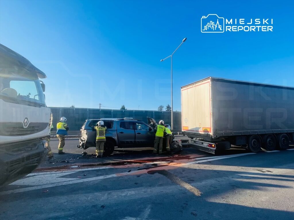 Ratownicy w kamizelkach odblaskowych sprawdzają uszkodzone samochody po wypadku drogowym na ruchliwej drodze.