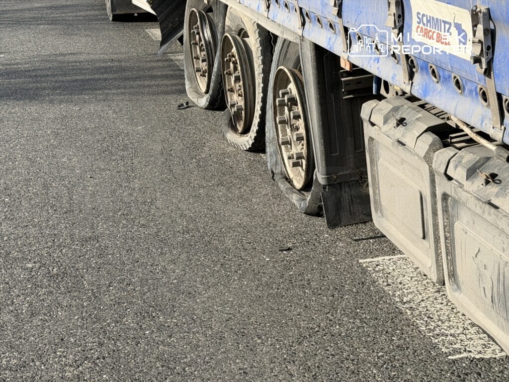 Uszkodzone opony ciężarówki leżą na drodze, obok widoczna jest zniszczona felga.