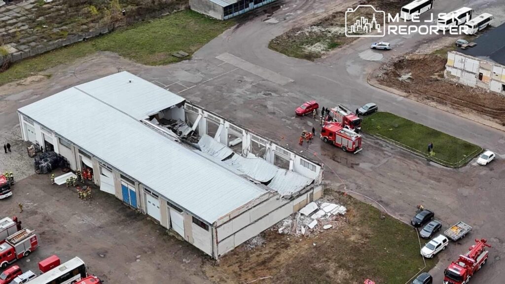 Grupa strażaków i ratowników pracuje przy zniszczonym budynku, gdzie część dachu się zawaliła.