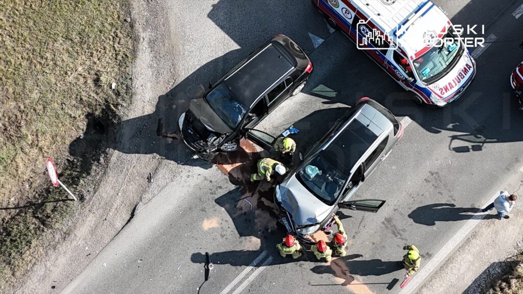 Wielu strażaków udziela pomocy poszkodowanym po zderzeniu dwóch samochodów na drodze.