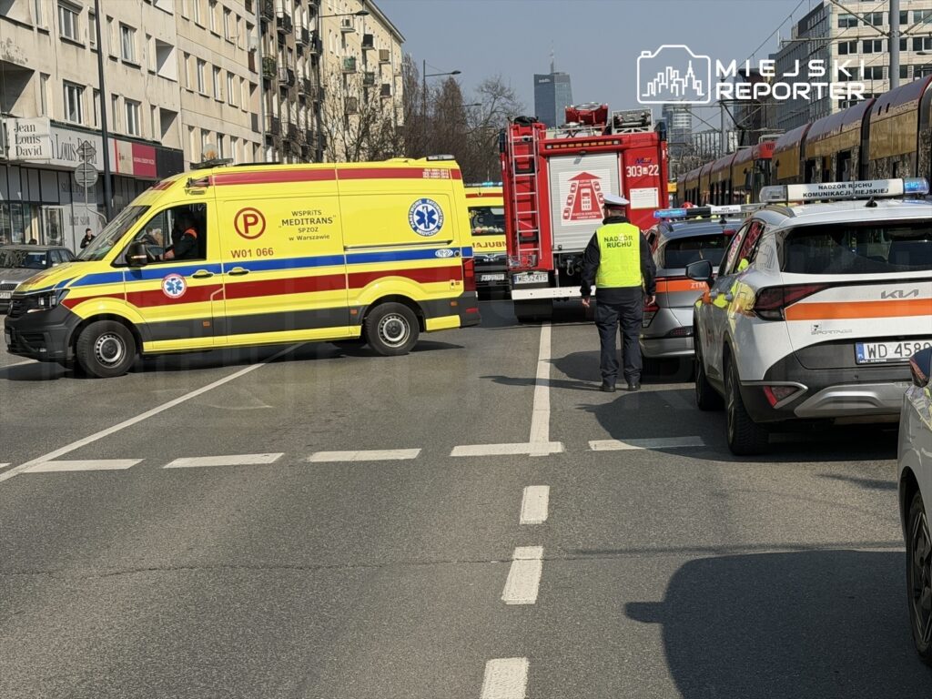 Zespół ratownictwa medycznego i straż pożarna interweniują na ulicy w mieście, blokując ruch.