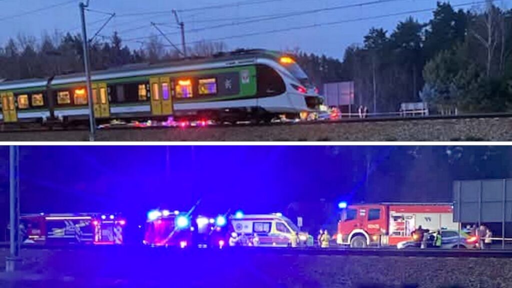 Pociąg pasażerski zatrzymany na torach, w tle widoczne niebieskie światła pojazdów ratunkowych.