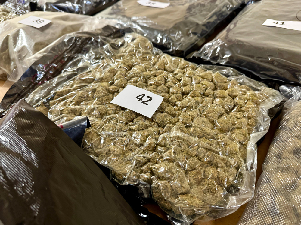 Pakiety z zielonym suszem, oznaczone numerami, leżą na stole w przezroczystych opakowaniach.