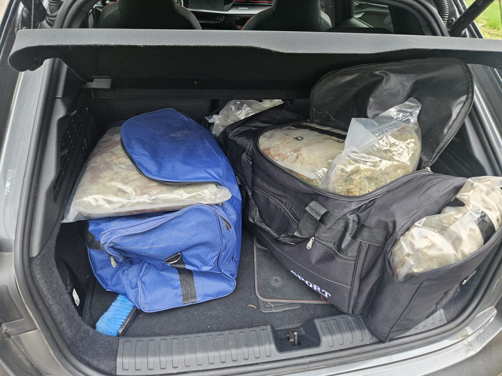 W bagażniku samochodu znajdują się torby sportowe wypełnione przezroczystymi workami z nieznaną zawartością.