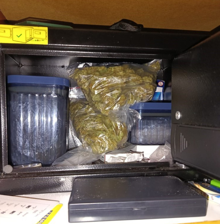 Pojemnik z zielonymi substancjami, plastikowe słoiki i opakowania w zamkniętej skrzynce.