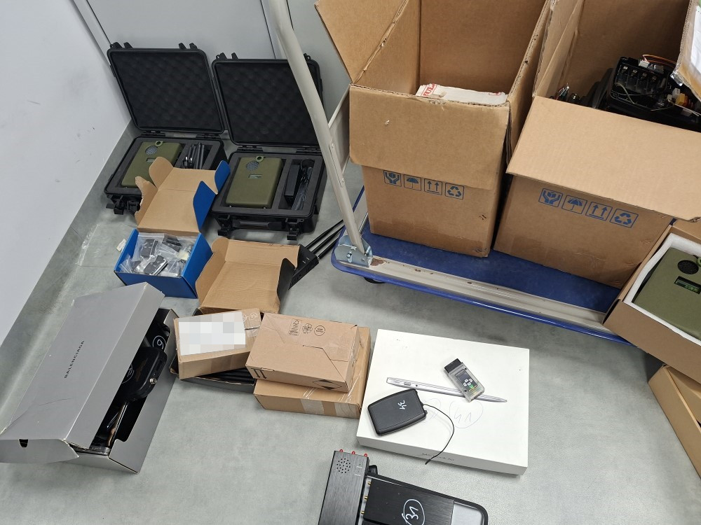 Zestaw pudełek i walizek z różnymi przedmiotami leży na posadzce w magazynie.