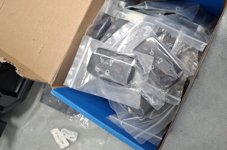 Pudełko z przezroczystymi woreczkami, w których znajdują się kluczyki do samochodów.