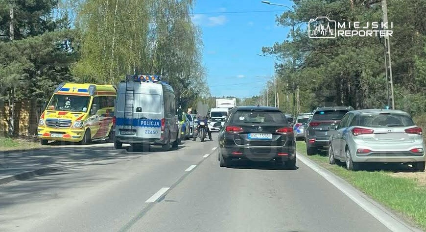Na drodze stoją pojazdy służb ratunkowych oraz policyjnych, a obok widać zablokowane samochody osobowe.
