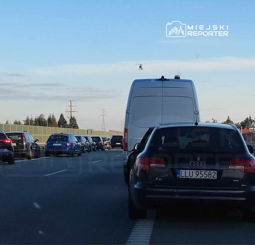 Ruch samochodowy w obie strony z widoczną korkiem na drodze, nad którym unosi się dron.