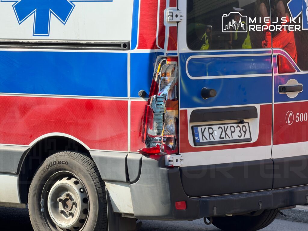Zniszczona tylna część karetki pogotowia z widocznym uszkodzeniem lampy i tablicą rejestracyjną.