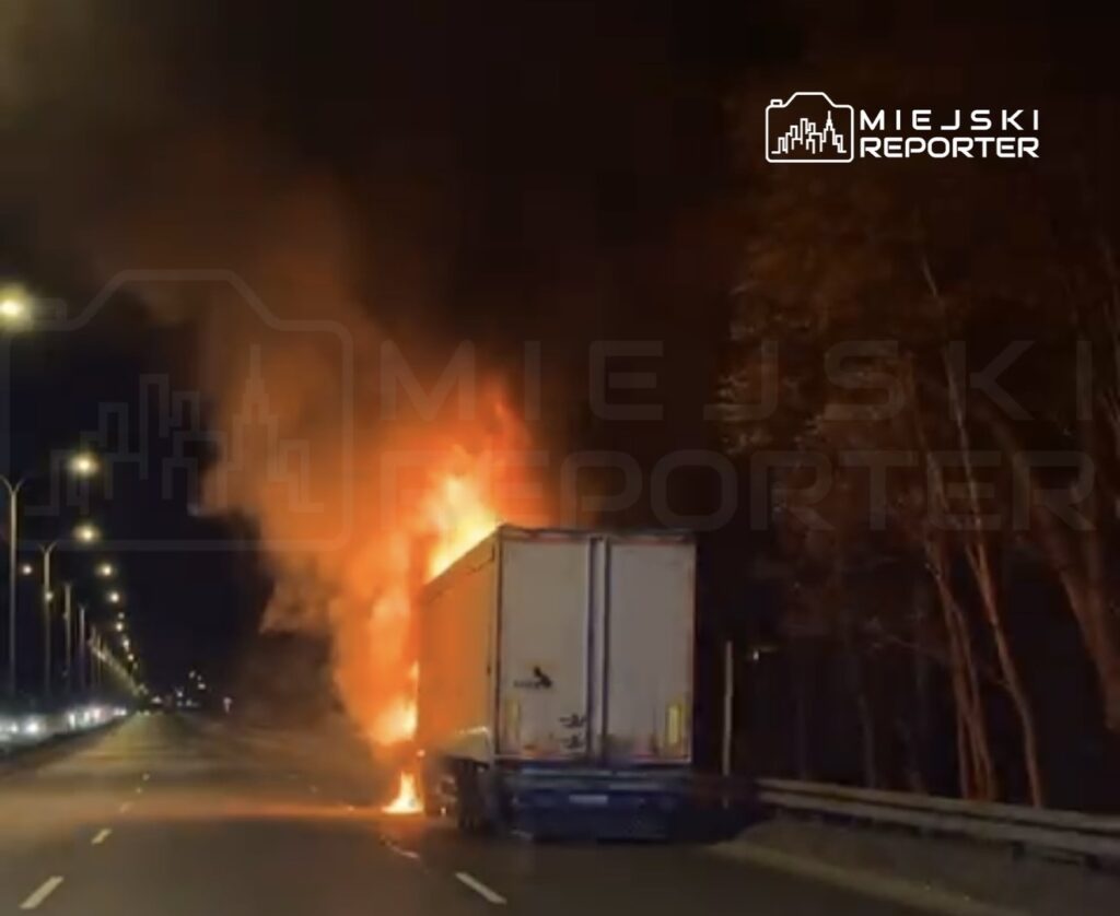 Tir zapalił się na pasie drogi, wydobywając intensywny ogień i dym w nocy.